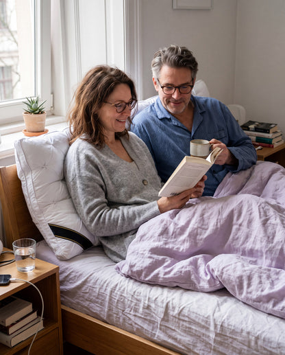 Paar liest im Bett, angelehnt an Wolkenkissen