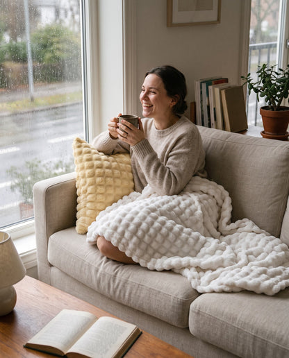 Frau eingekuschelt in die Marshmallow-Decke auf dem Sofa